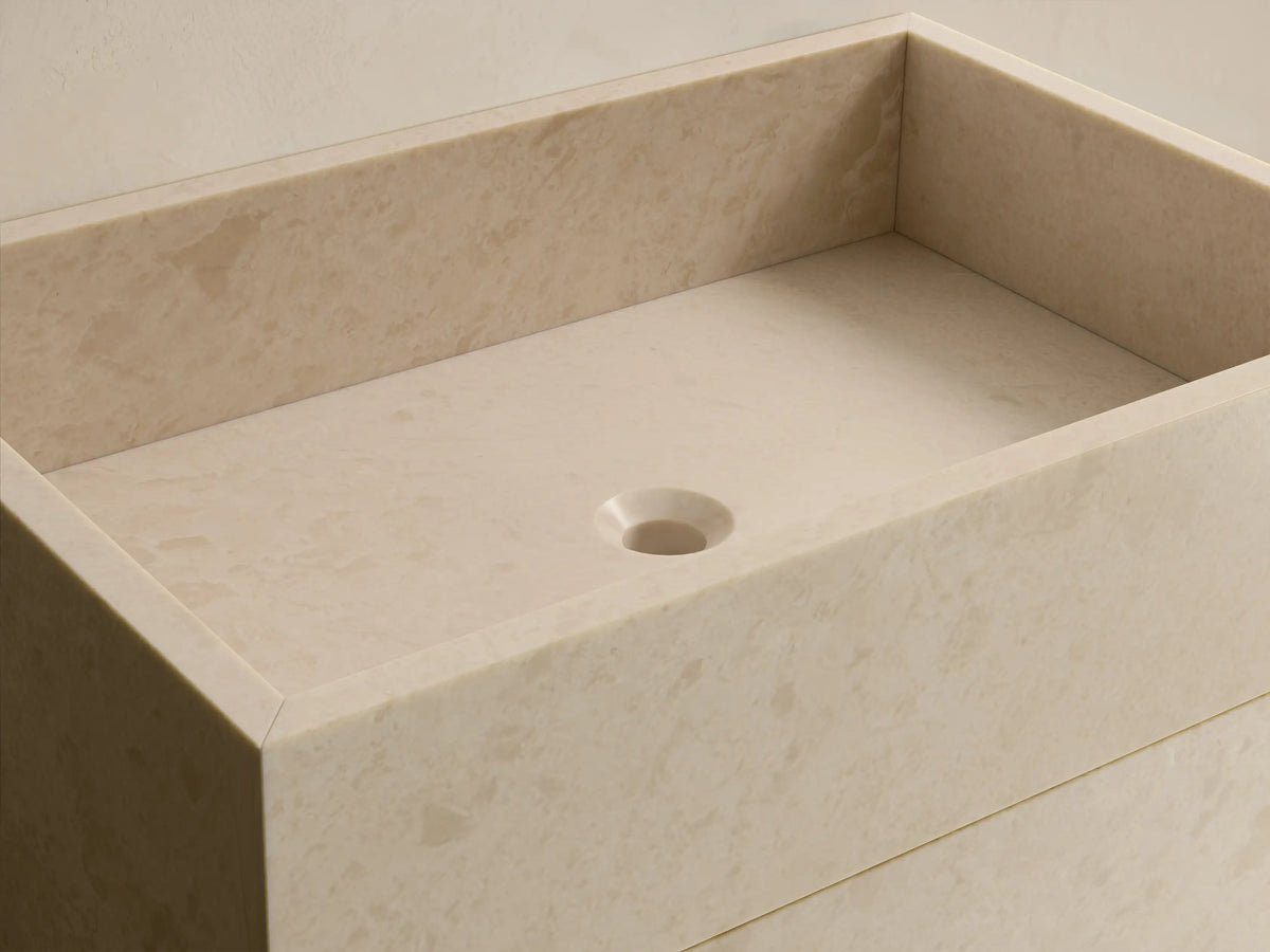 Front view of beige natural stone Vertiz Pedestal Sink with Storage, featuring a rectangular form and a single soft-close door.