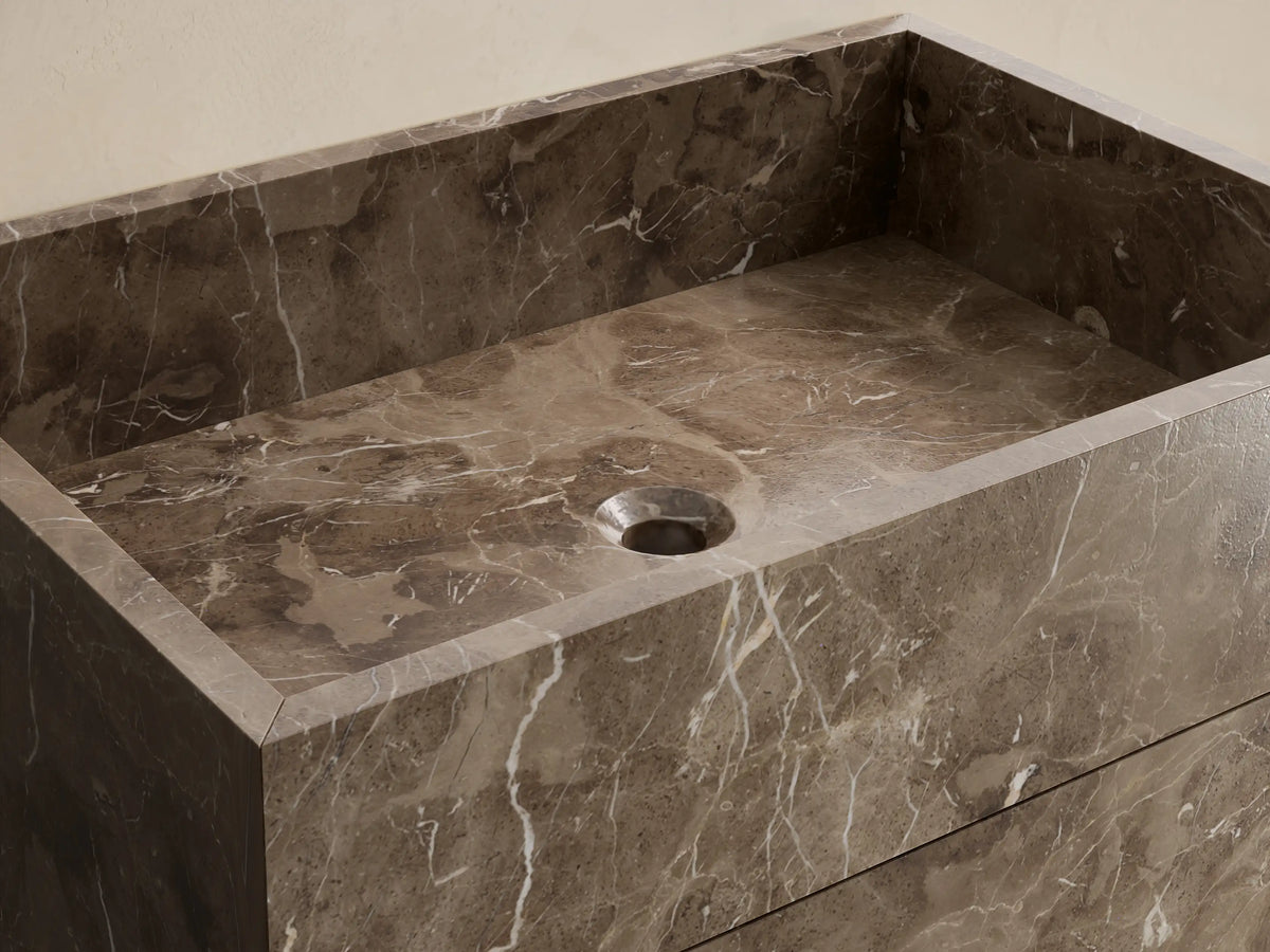 Front view of the dark brown honed stone Vertiz Pedestal Sink with Storage, featuring subtle white veining and clean lines.