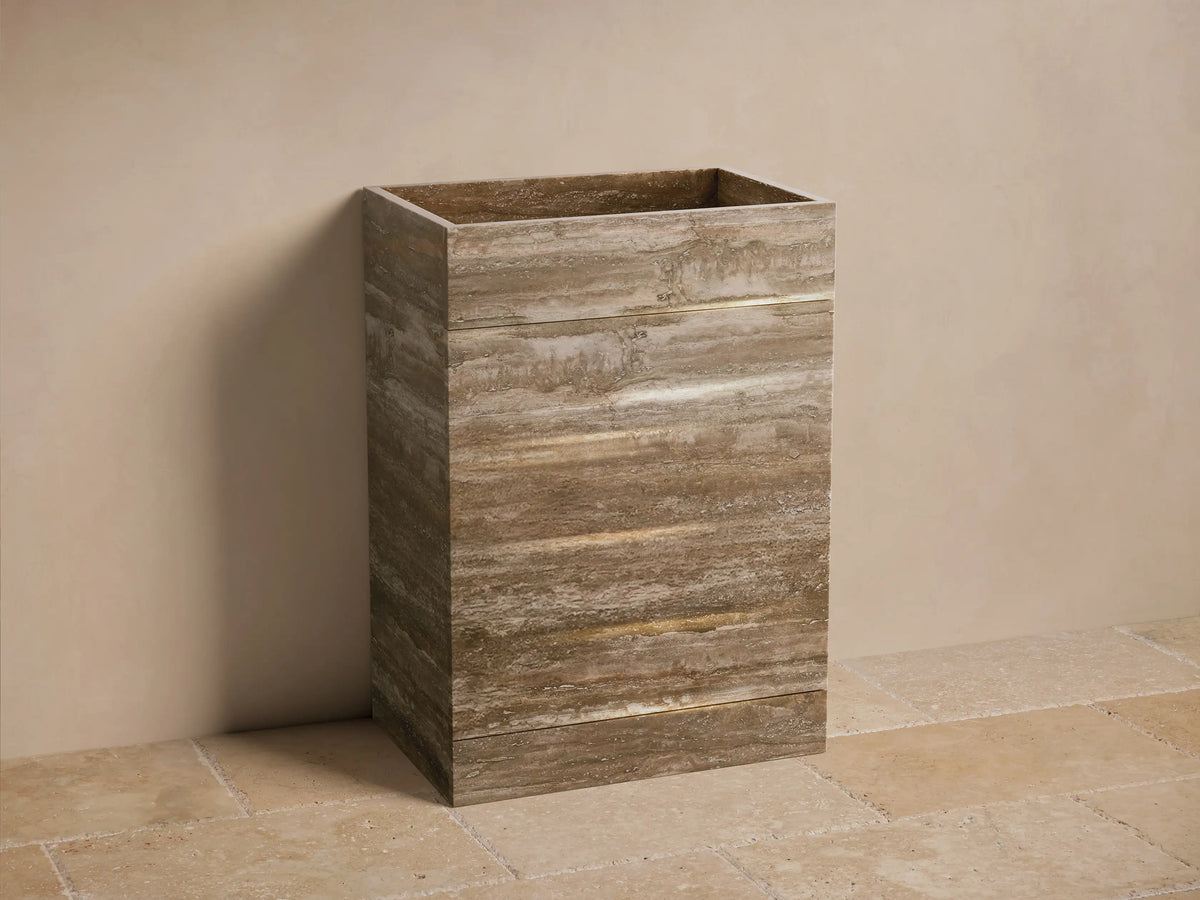 Front view of the brown and beige Vertiz Pedestal Sink with Storage, featuring natural stone with horizontal striations.