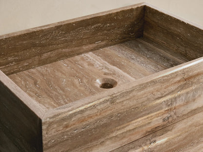 Front view of the Vertiz Pedestal Sink with Storage, featuring a light and dark brown natural stone exterior with horizontal veining.
