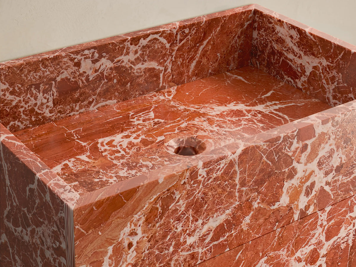 Front view of the reddish-brown marble Vertiz Pedestal Sink with Storage, featuring white veining and a rectangular form.