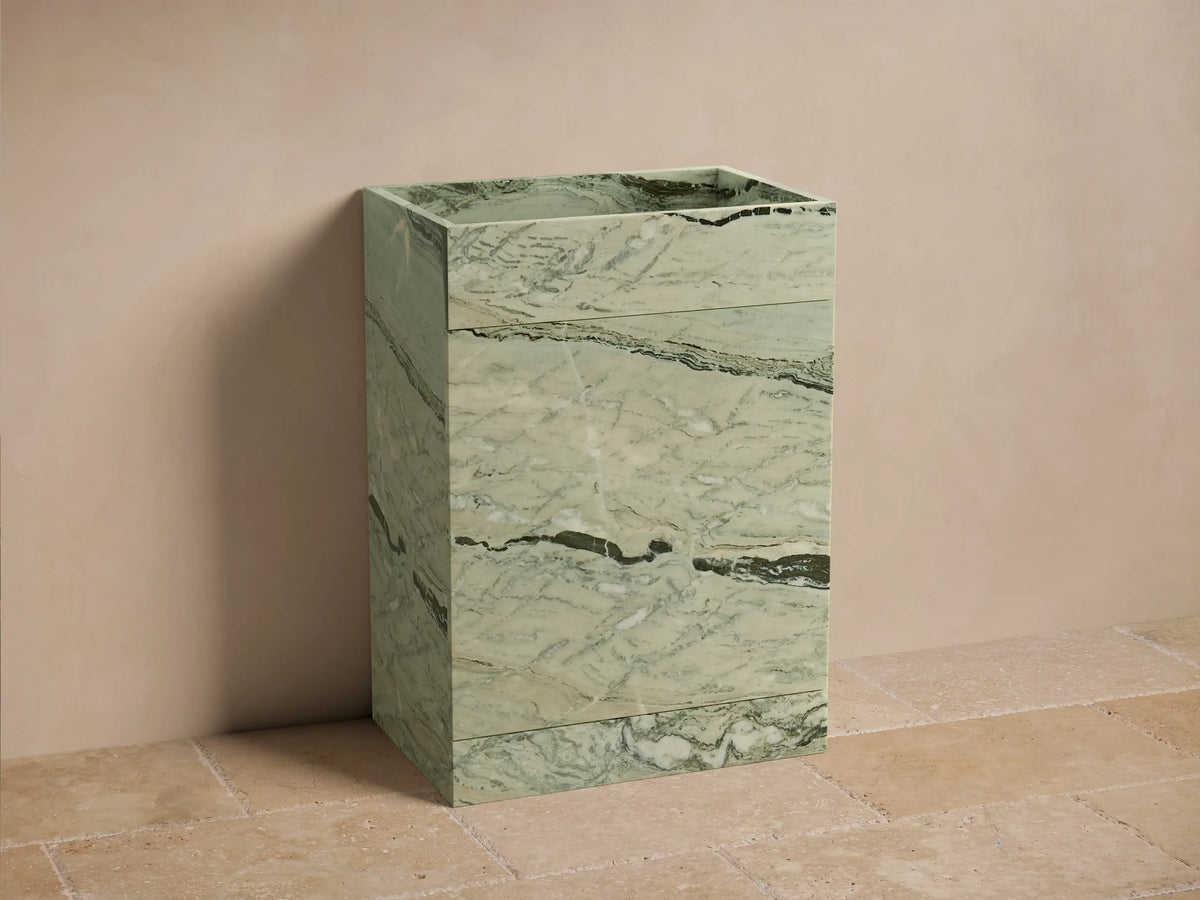 Front view of the light green marble Vertiz Pedestal Sink with Storage, featuring prominent dark veining.