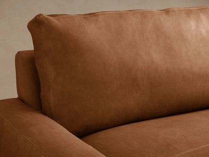 Remington Leather Two-Piece Chaise Sectional in rich, warm brown leather with a right-hand chaise, on a light wood floor.