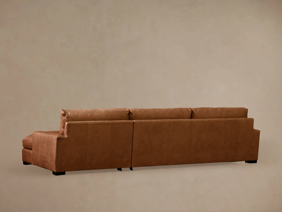 Close-up of Remington Leather Chaise Sectional's soft, tan-brown leather back and seat cushions with fine stitching.