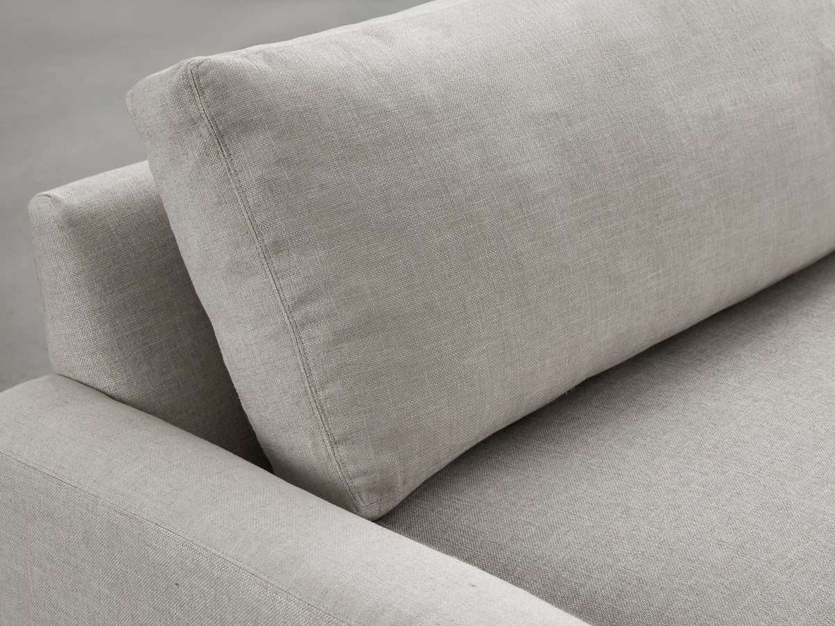 Modern Remington Sofa in light beige fabric, a two-seater with wide square arms and two seat cushions, against a gray studio background.