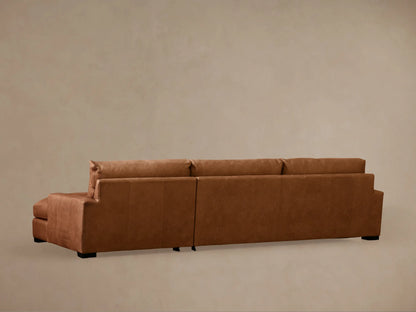 Close-up of the Remington leather sectional's warm brown cushions, highlighting the soft texture and precise stitching.