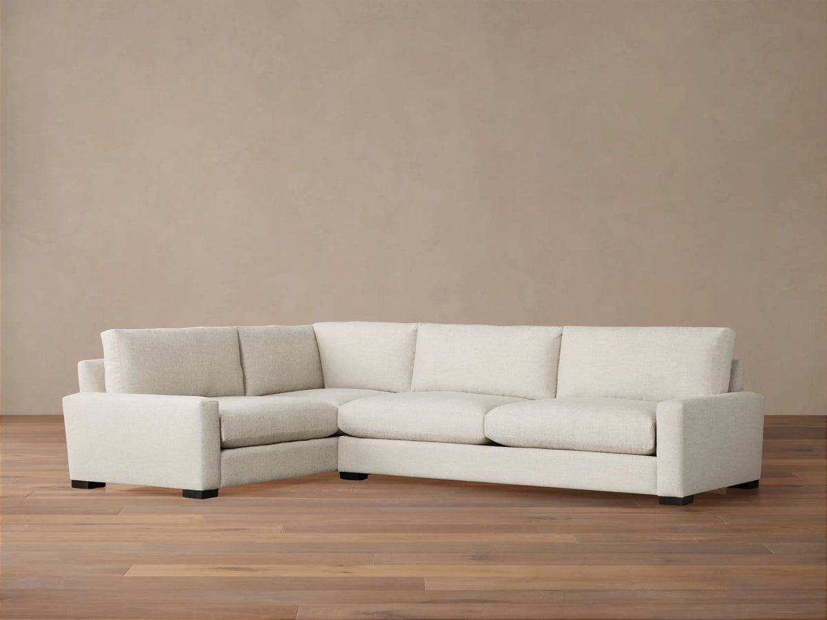 Remington Two-Piece Sectional, L-shaped, upholstered in light beige fabric, with plush cushions on a wood floor.