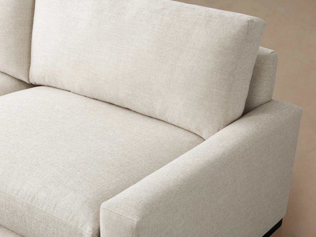 Remington Two-Piece Sectional, L-shaped, in a light natural fabric, with clean lines, on a wood floor against a neutral wall.