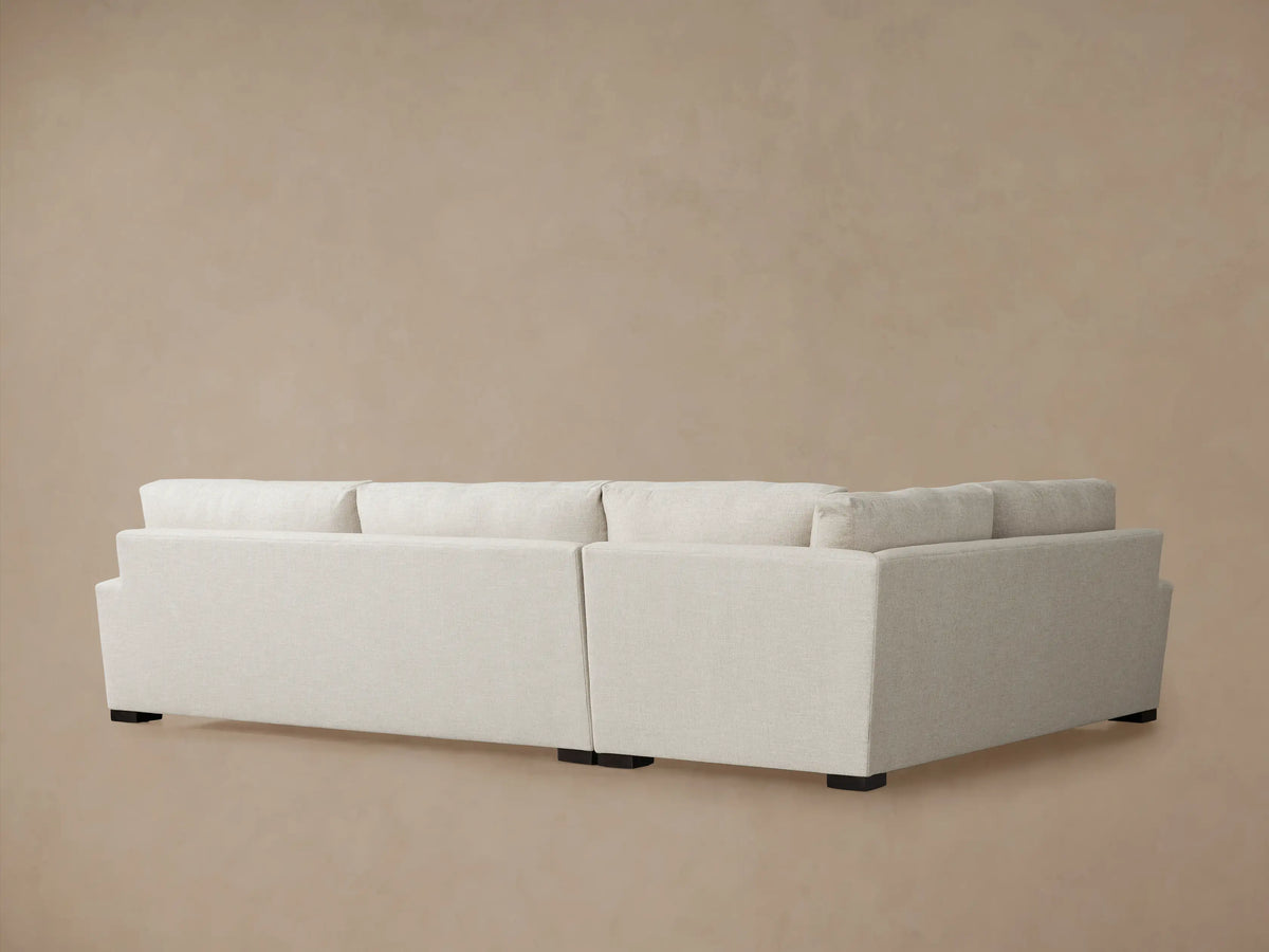 Close-up of a Remington Two-Piece Sectional in light beige textured fabric, showing the plush seat, back cushions, and armrest.