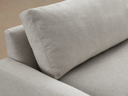 Remington Sofa: light gray textured fabric, 2 plump seat & back cushions, wide square arms, dark feet, on a wood floor.