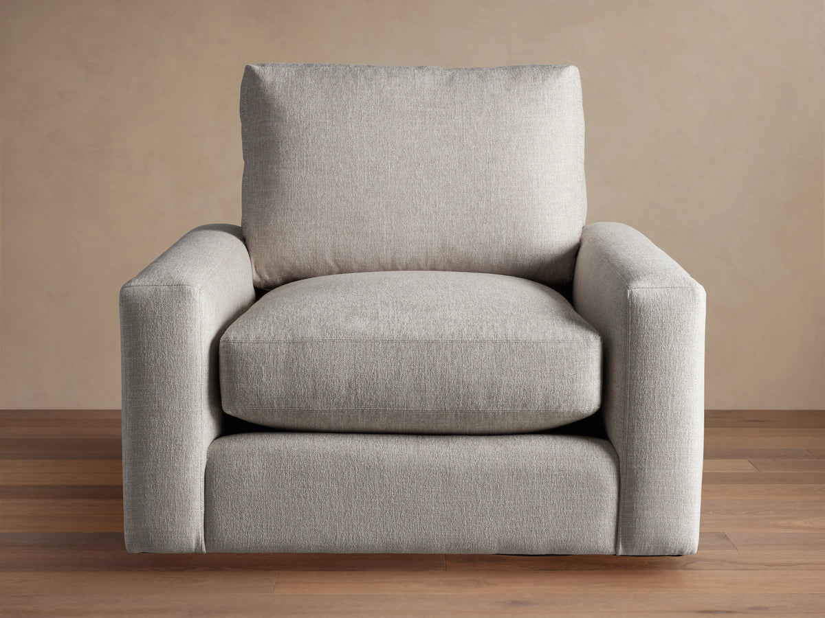 Front view of an oatmeal-colored Remington Swivel Chair, featuring a boxy design with thick cushions and wide arms.