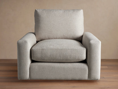 Front view of an oatmeal-colored Remington Swivel Chair, featuring a boxy design with thick cushions and wide arms.