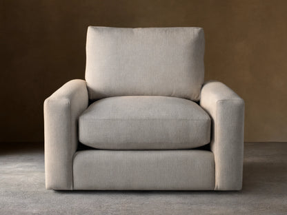 Front view of an oatmeal-colored Remington Swivel Chair, featuring a boxy design with thick cushions and wide arms.