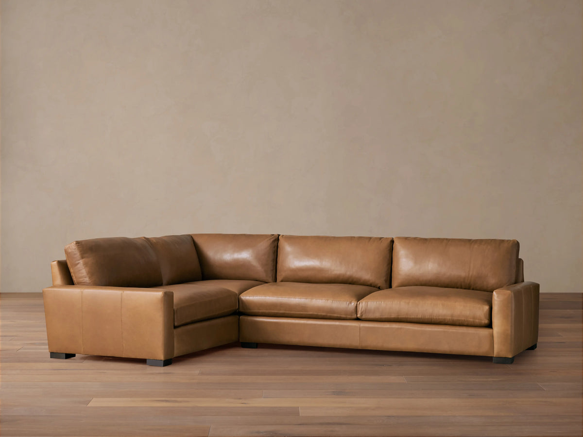 Remington Leather Two-Piece Sectional in Saratoga Chocolate, L-shaped, with soft brown leather & plump cushions on a wood floor.
