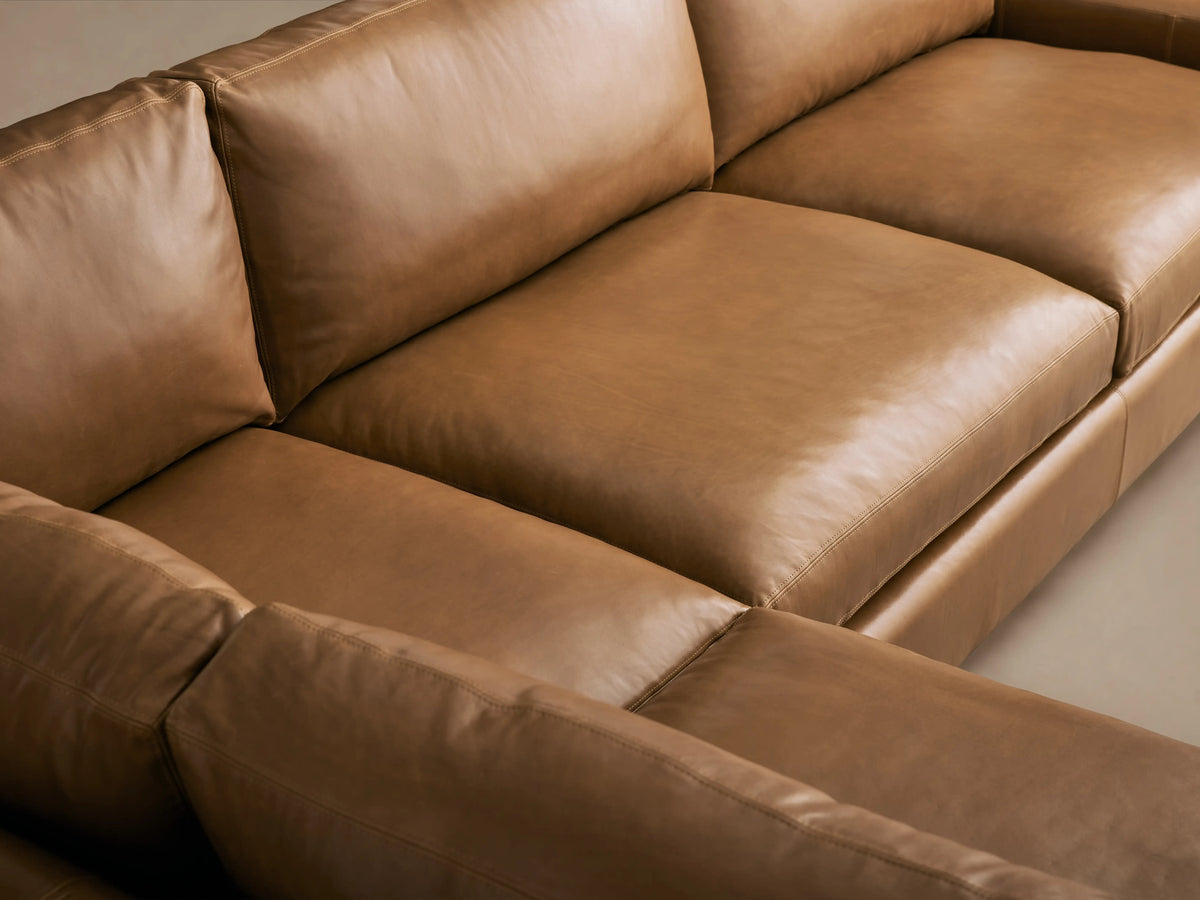 Remington L-shaped two-piece sectional in Saratoga Chocolate brown leather, with plush cushions, on a wood floor.