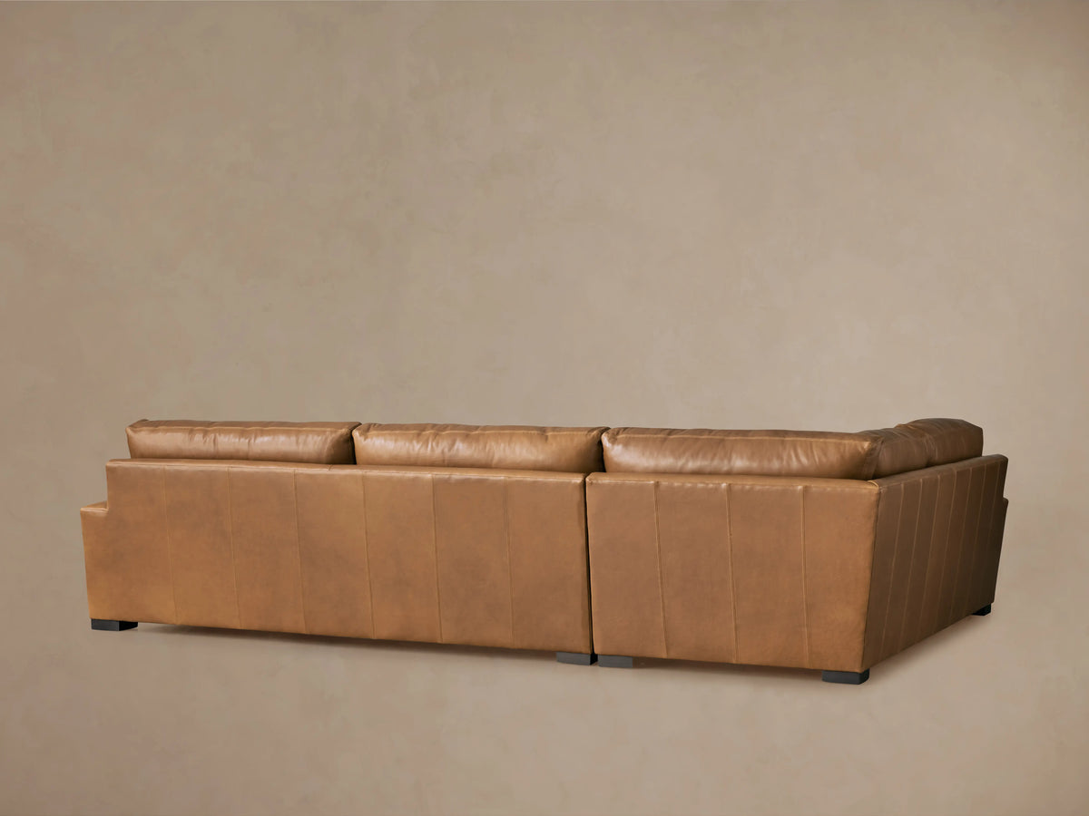 Close-up of Remington Leather Two-Piece Sectional, showing warm brown Saratoga Chocolate leather, soft cushions, and visible stitching.