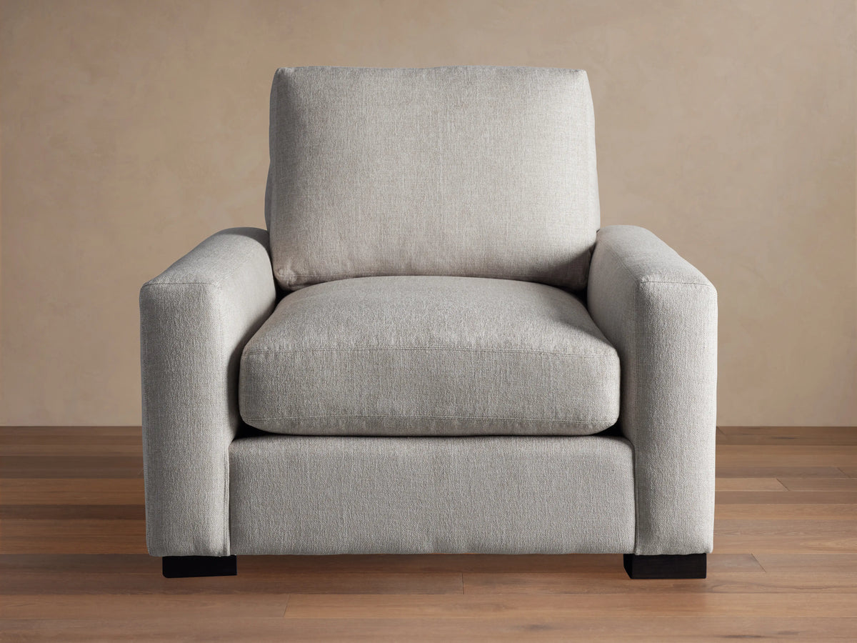 Front view of a light gray Remington Chair with thick, straight arms, plush seat and back cushions, and dark rectangular feet.