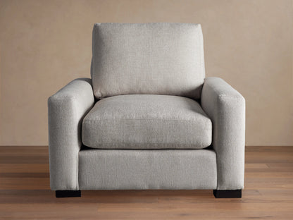 Front view of a light gray Remington Chair with thick, straight arms, plush seat and back cushions, and dark rectangular feet.