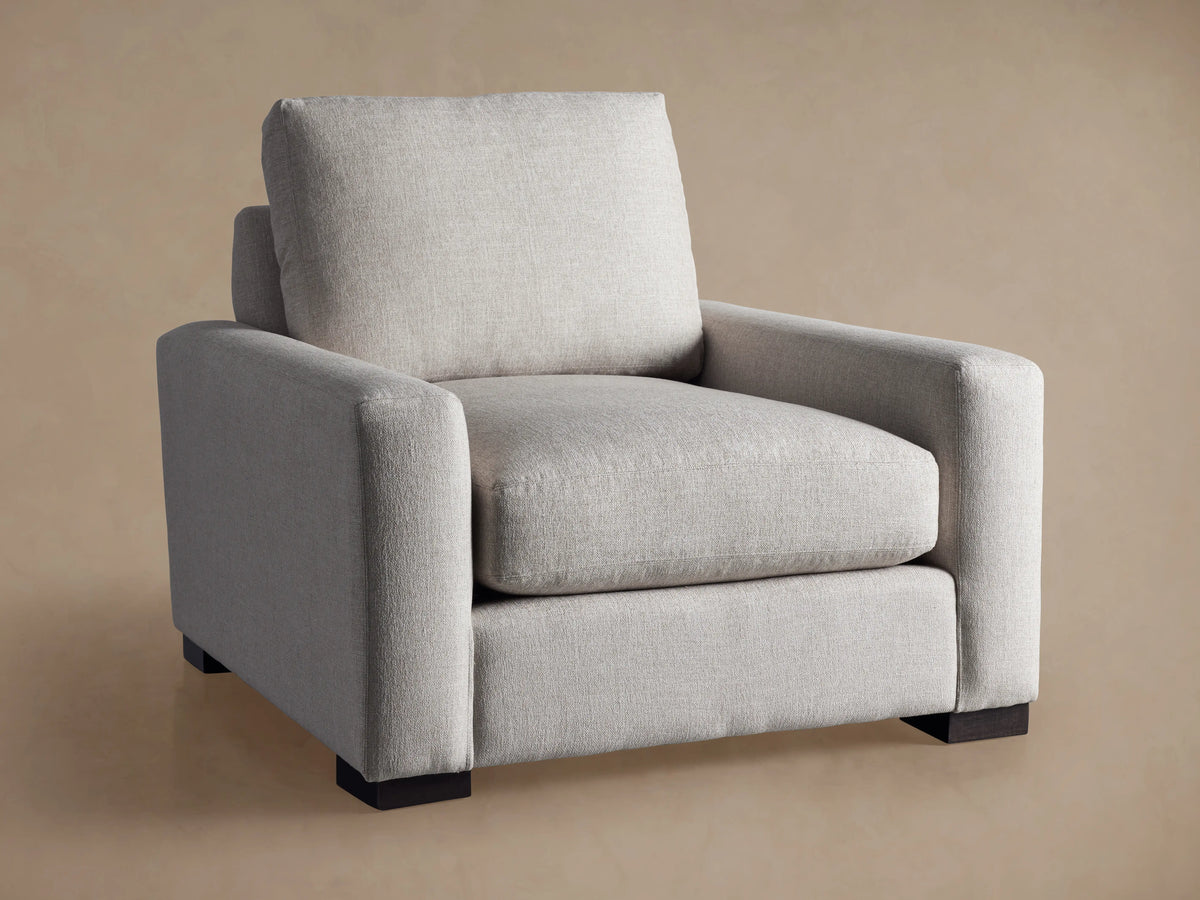 Front angled view of the light gray fabric Remington Chair with dark wood block legs.