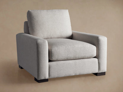 Front angled view of the light gray fabric Remington Chair with dark wood block legs.