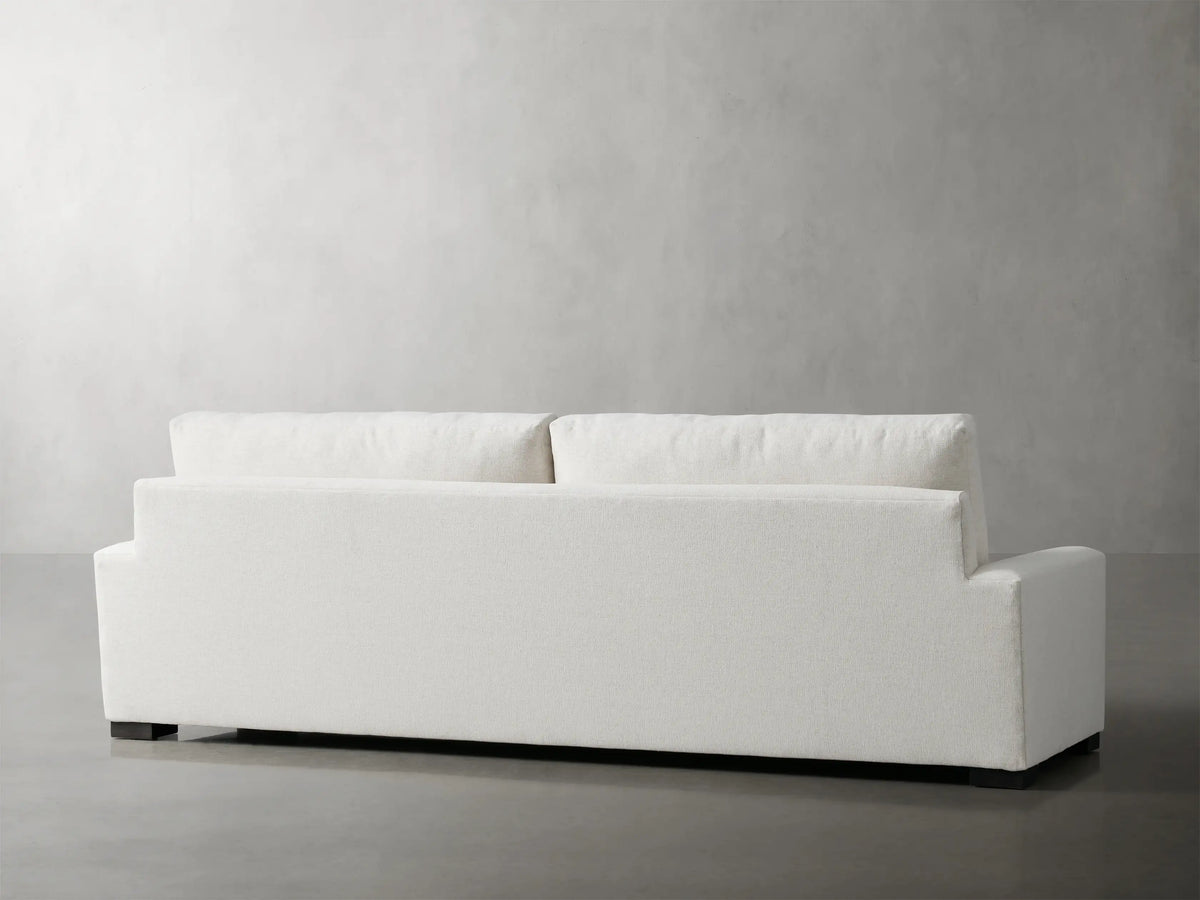 Remington Sofa, close-up of light-colored woven fabric on armrest, seat, and back cushions, viewed from an angle.