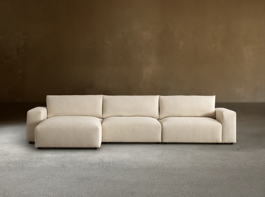 Keegan Tailored Three-Piece Chaise Sectional in textured cream fabric. Left-facing chaise, two seats, light brown wall, wood floor.