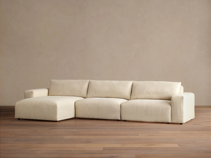 Keegan Tailored Three-Piece Chaise Sectional in textured cream fabric. Left-facing chaise, two seats, light brown wall, wood floor.