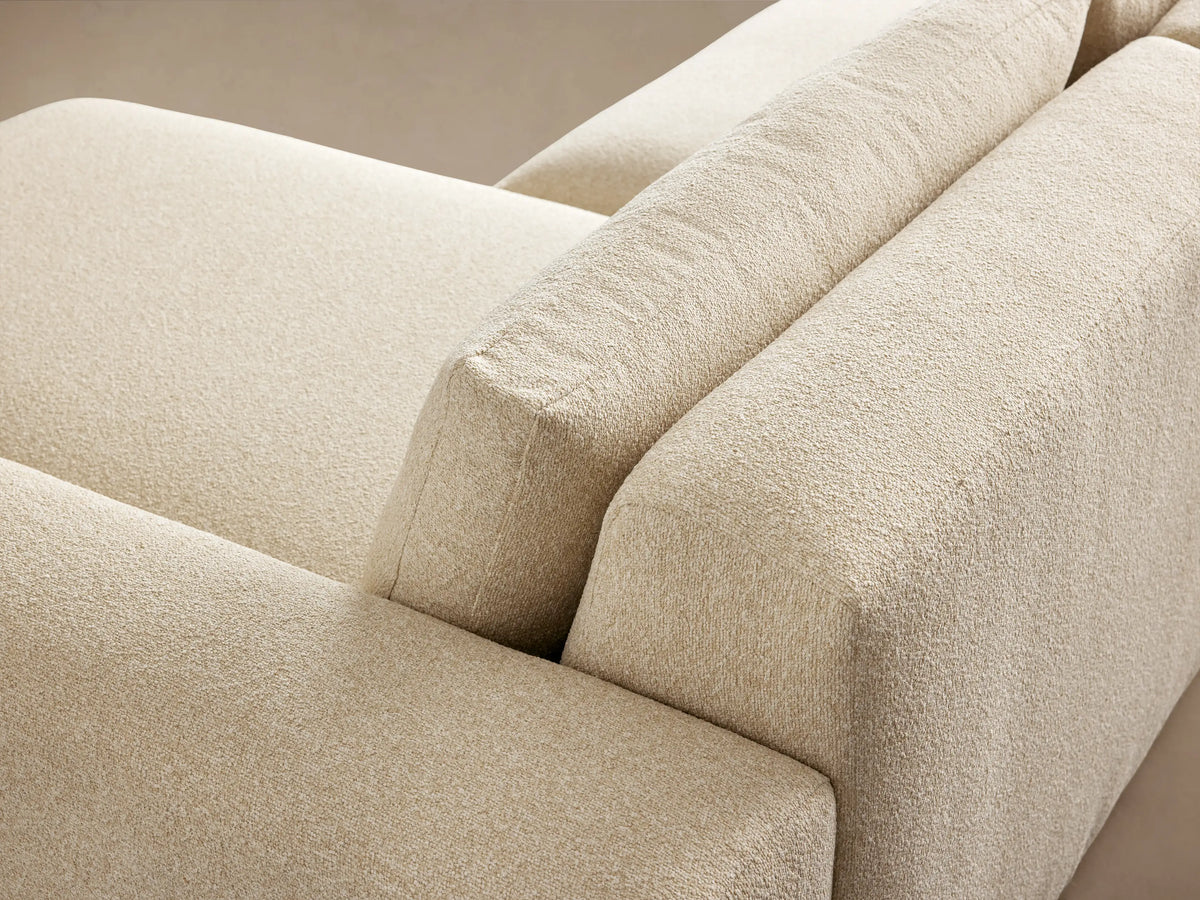 Keegan Tailored Three-Piece Sectional, light cream, right-hand chaise, textured fabric, against beige wall, wood floor.