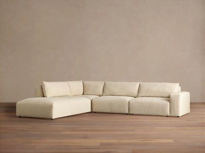 Off-white textured Keegan Tailored Four-Piece Bumper Sectional, L-shaped, with a left chaise, against a neutral wall.