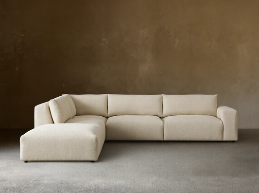 Light beige textured Keegan Tailored Five-Piece Sectional sofa with L-shape, chaise on left, on a wood floor.