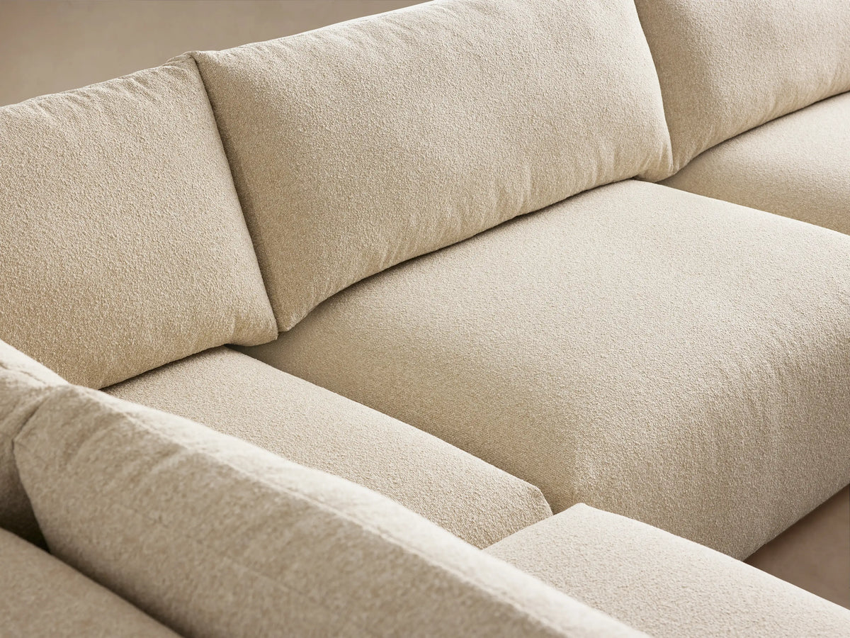 L-shaped Keegan Tailored Five-Piece Sectional in light cream textured fabric, with a chaise on wood floor.