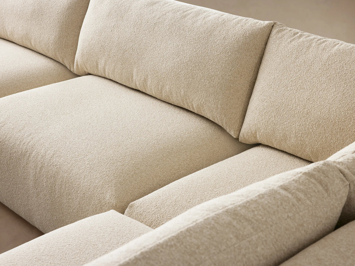 Keegan Tailored Five-Piece Sectional in L-shape, light cream textured fabric, on wood floor against a beige wall.