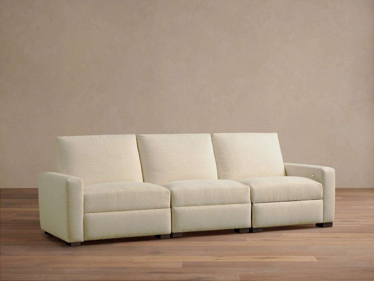 Front view of the cream Remington Three-Piece Motion Sofa, showing its three individual reclining sections.