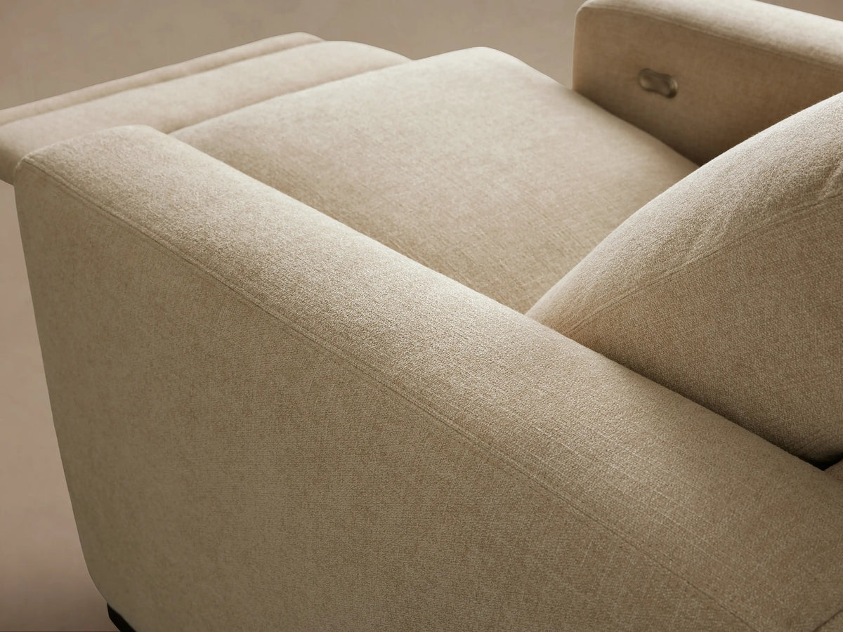 Close-up of the light beige Remington Motion Recliner, showing the silver oval-shaped control panel on the side.