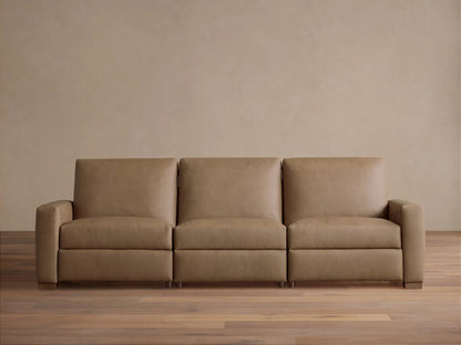 Remington Three-Piece Motion Sofa in tan leather, featuring clean lines and square arms, sits centered on a wood floor.