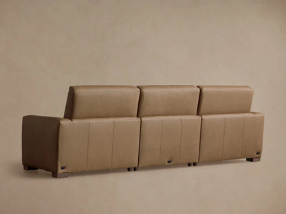 Close-up of a tan leather Remington Motion Sofa, showing smooth cushions, visible stitching, and a partially reclined footrest.
