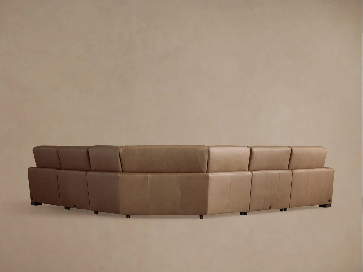 Close-up of a tan leather Remington motion corner sectional. Smooth texture, visible stitching, and an extended footrest are shown.