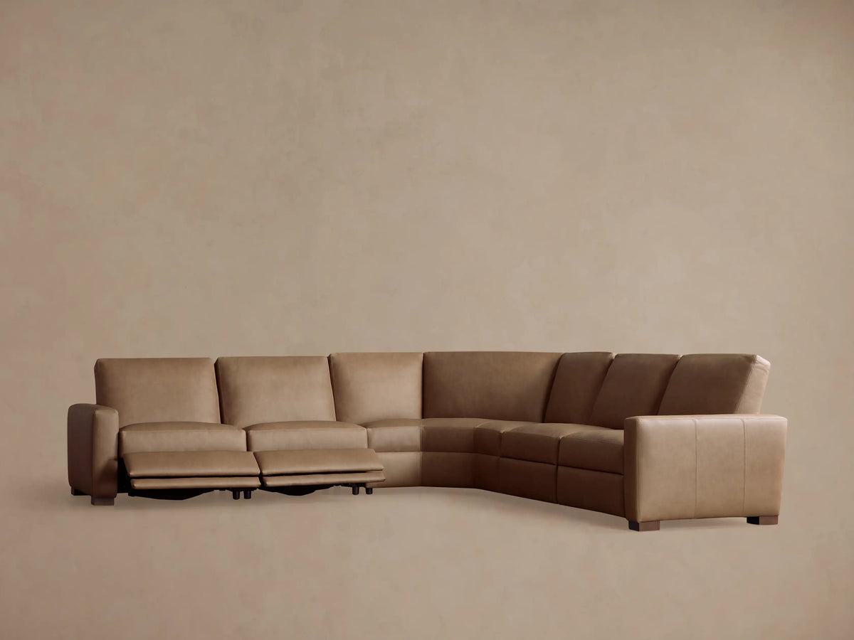 Remington Leather Five-Piece Motion Corner Sectional, back view. Light brown L-shaped sofa, segmented, against a warm neutral wall.