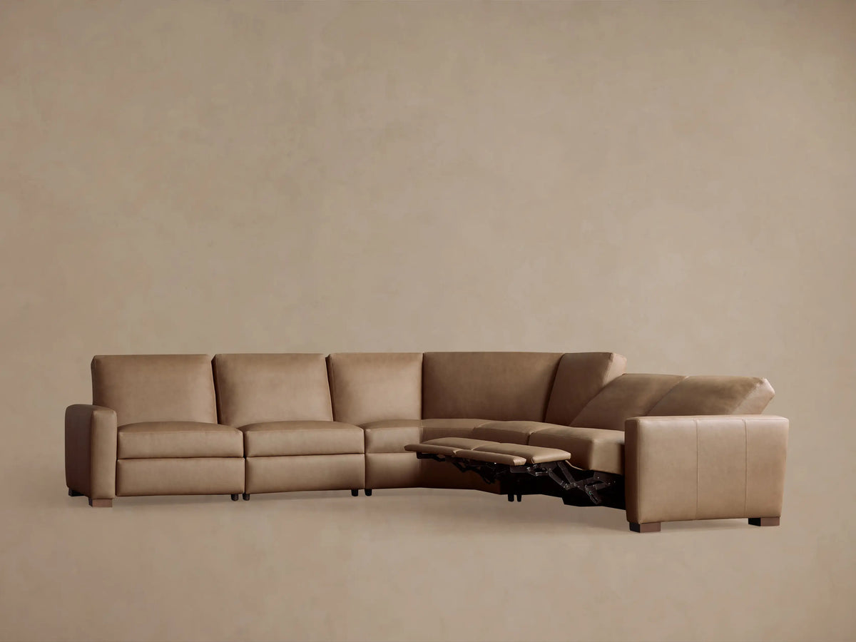 Remington Leather Five-Piece Motion Corner Sectional in tan. Left recliners extended, showing motion feature, on a neutral wall.