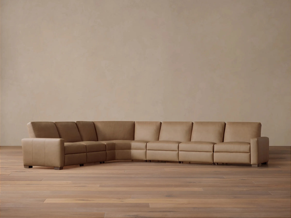 Front view of tan Remington Leather Six-Piece Motion Sectional, L-shaped, on a wood floor against a neutral wall.