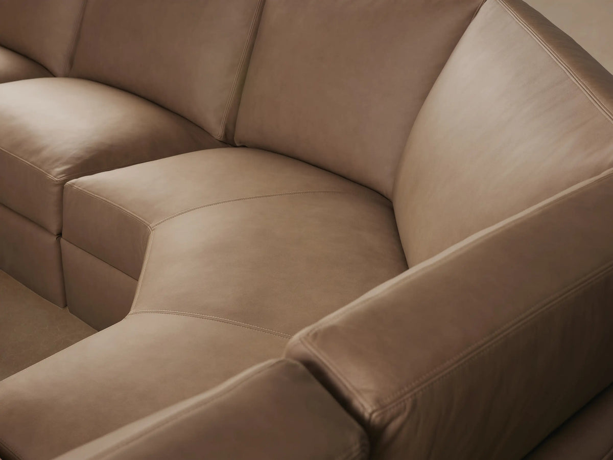 Remington Leather Six-Piece Motion Sectional: Close-up of taupe leather with stitching and an oval metallic silver control button.