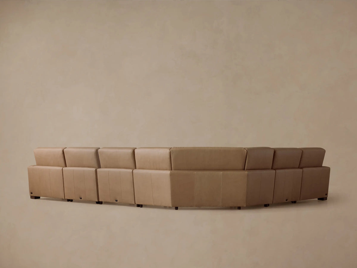 Detail of Remington Leather Six-Piece Motion Sectional. Tan leather, stitched seam, and silver power recline control with two buttons.