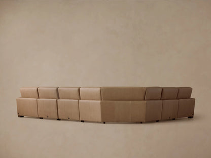 Detail of Remington Leather Six-Piece Motion Sectional. Tan leather, stitched seam, and silver power recline control with two buttons.