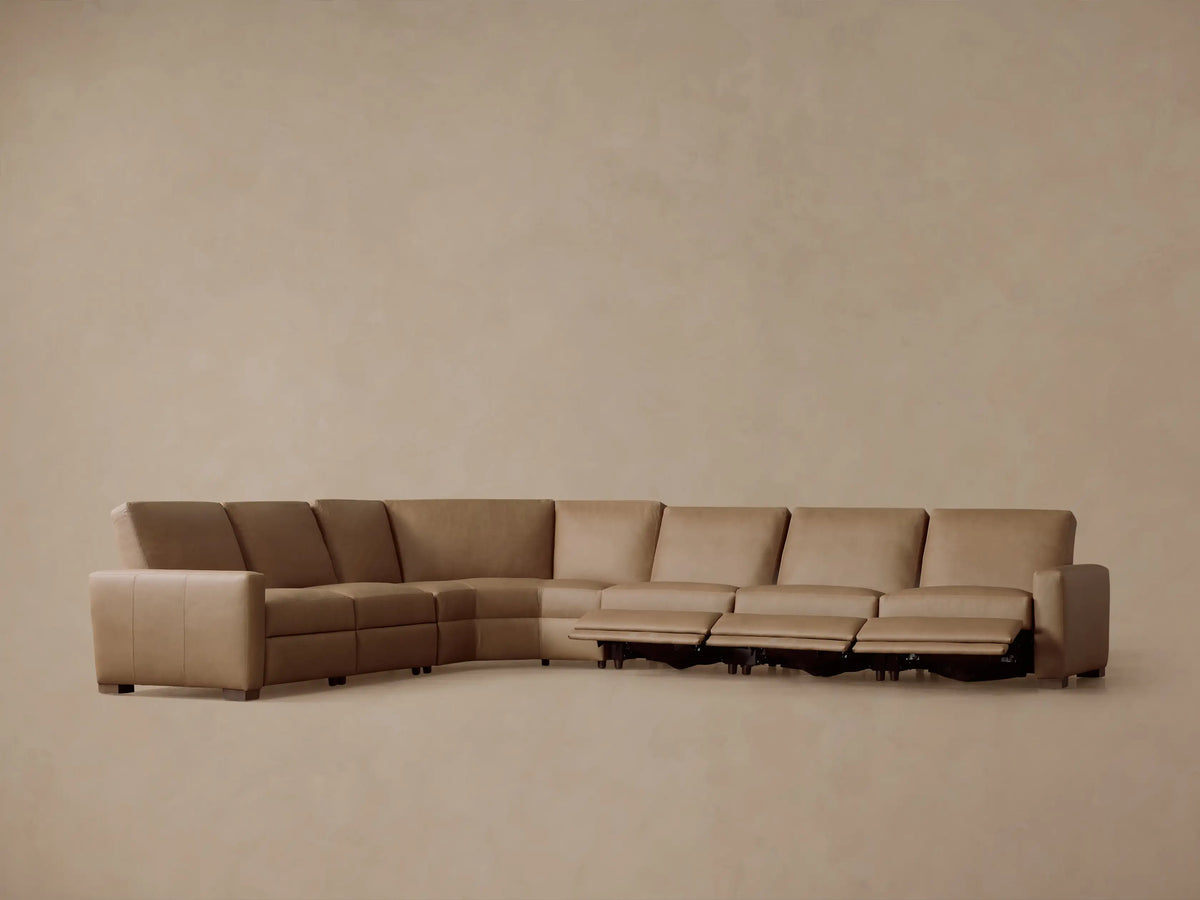 Tan Remington Leather Six-Piece Motion Sectional, rear view, curving broadly, on plain beige background.