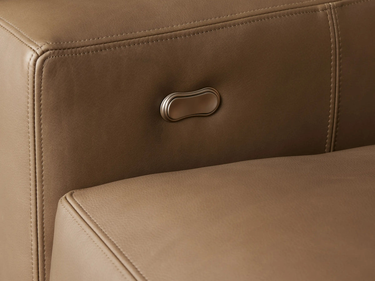 Remington Leather Motion Recliner in tan leather, angled view, showing block arms and plush seat on a wood floor.