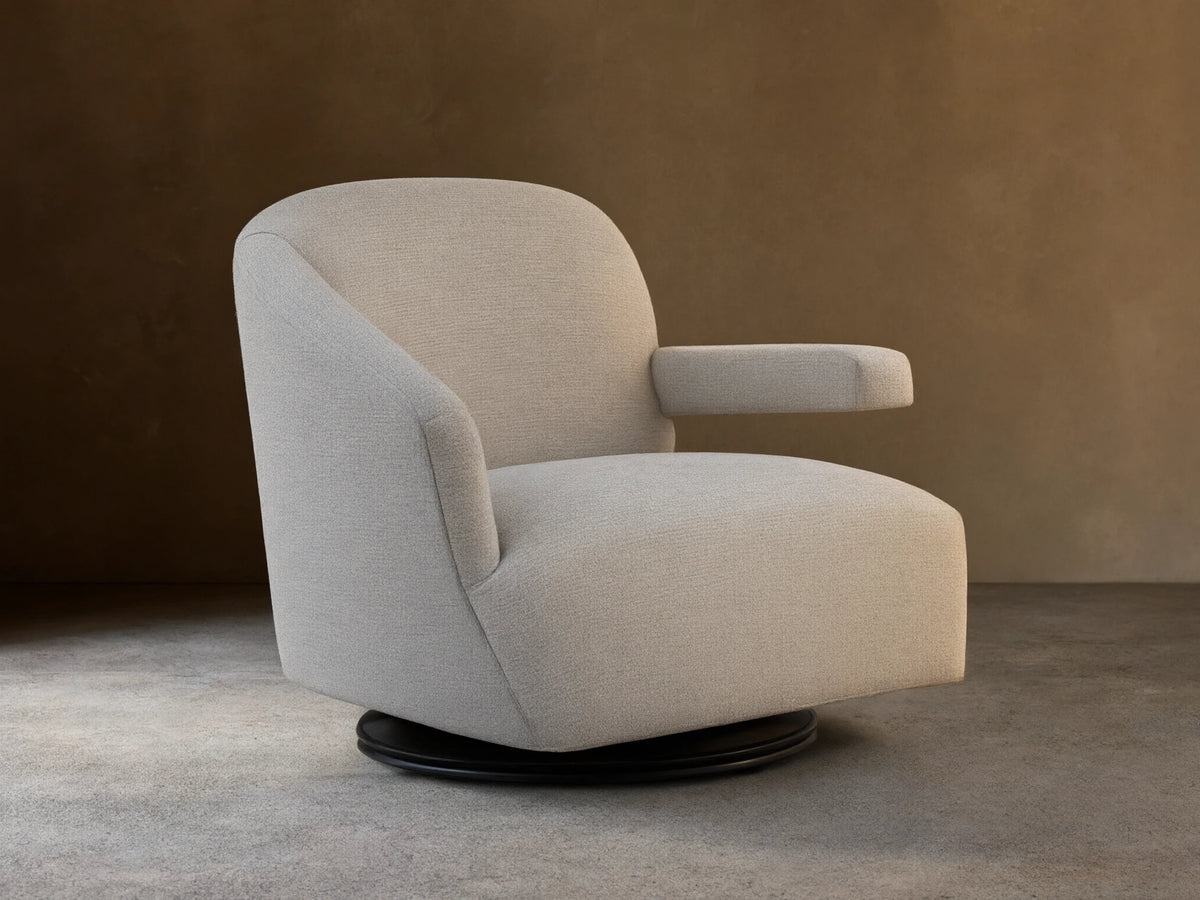 Oversized Ellison Swivel Chair, upholstered in light beige textured fabric, with curved arms & a visible black swivel base.