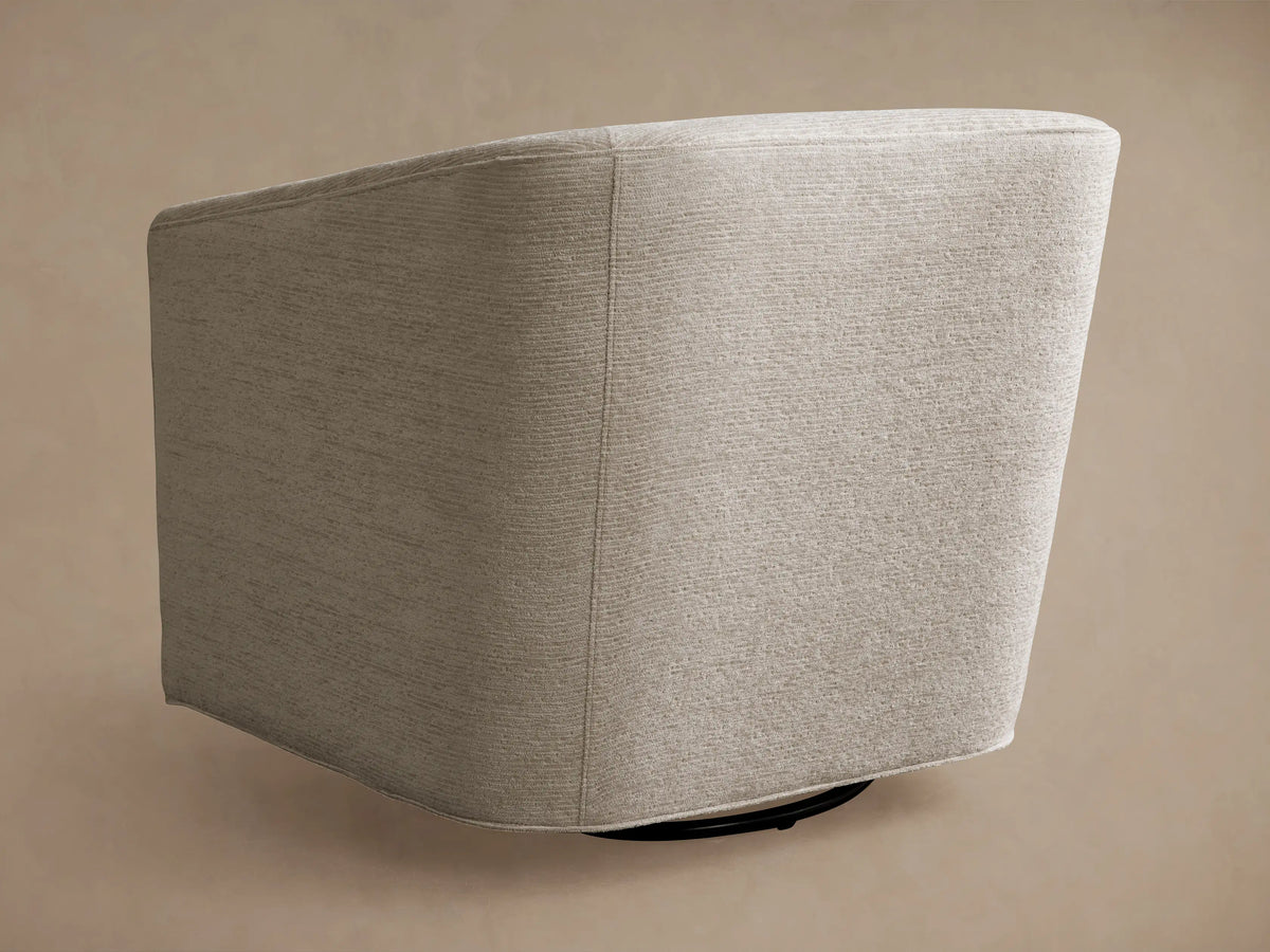Ellison Swivel Glider, close-up of a light cream curved armchair with subtle ribbed fabric texture on seat and backrest.