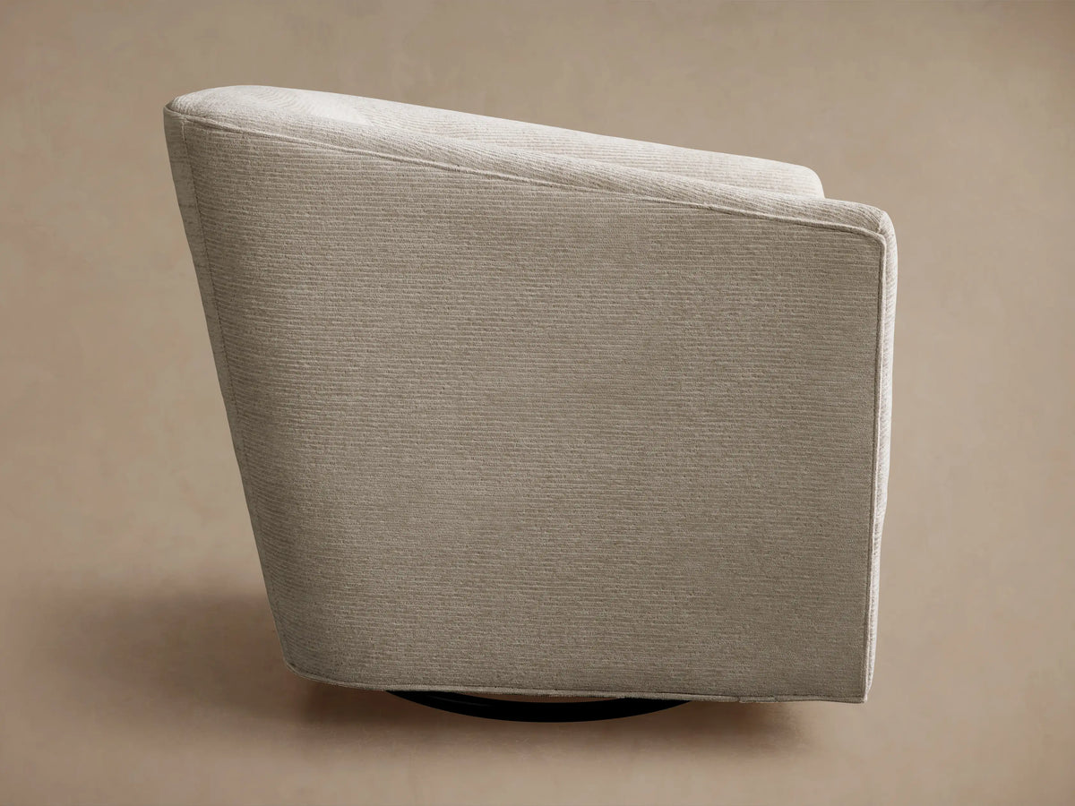 Ellison Swivel Glider upholstered in light beige, subtly textured fabric, seen from the back-side with a dark swivel base.