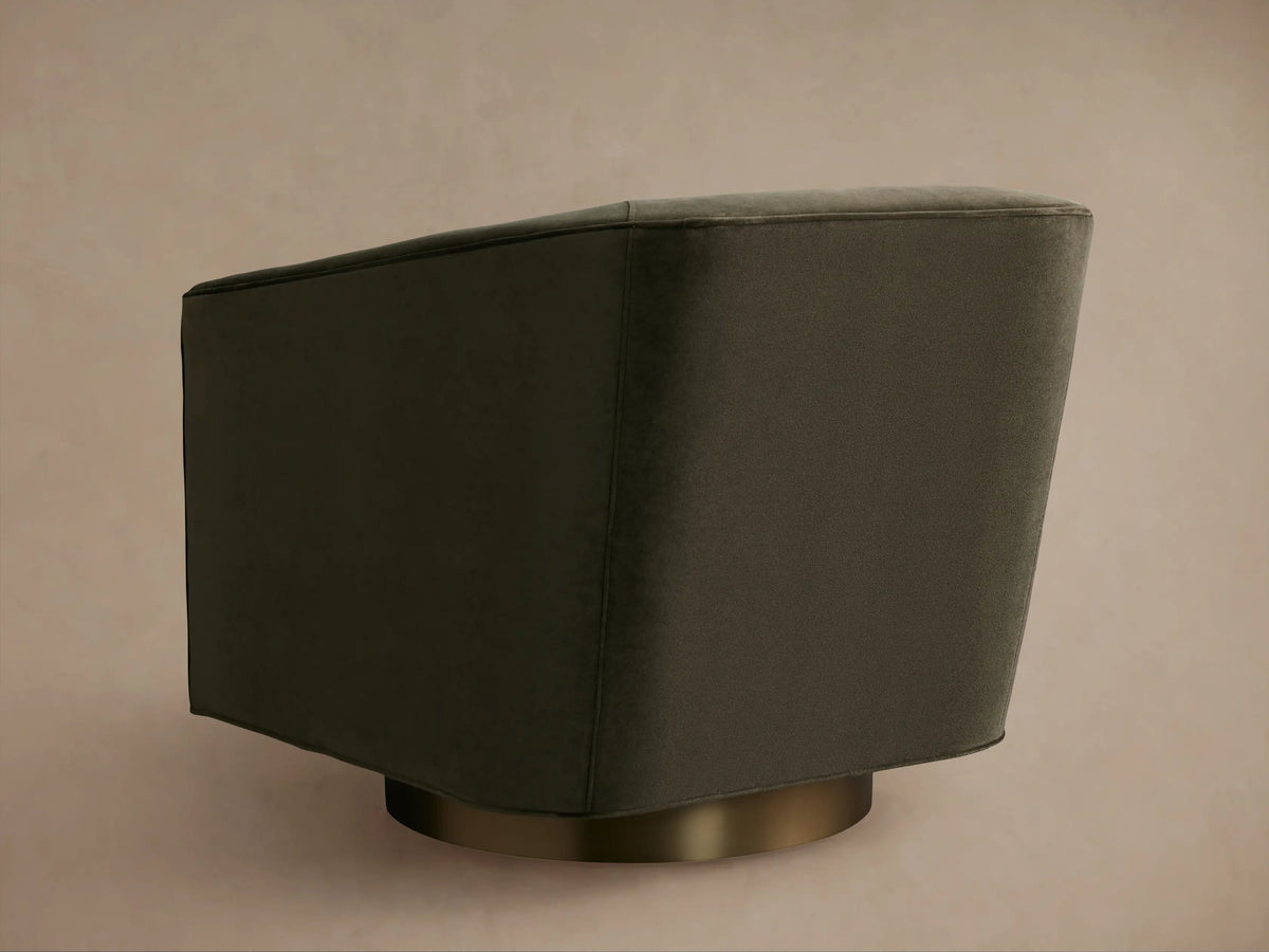 Ellison Metal Plinth Swivel Chair in dark gray fabric, side view. Features a smooth, solid base in metallic finish.