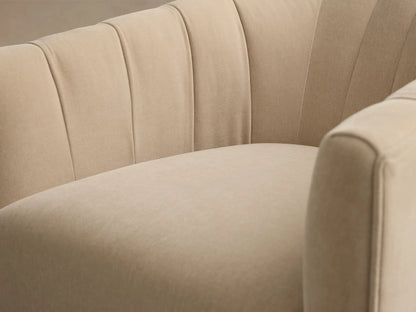 Close-up of the beige Ellison Channel-Stitched Metal Plinth Swivel Chair™ with its channel-stitched back and curved armrest.